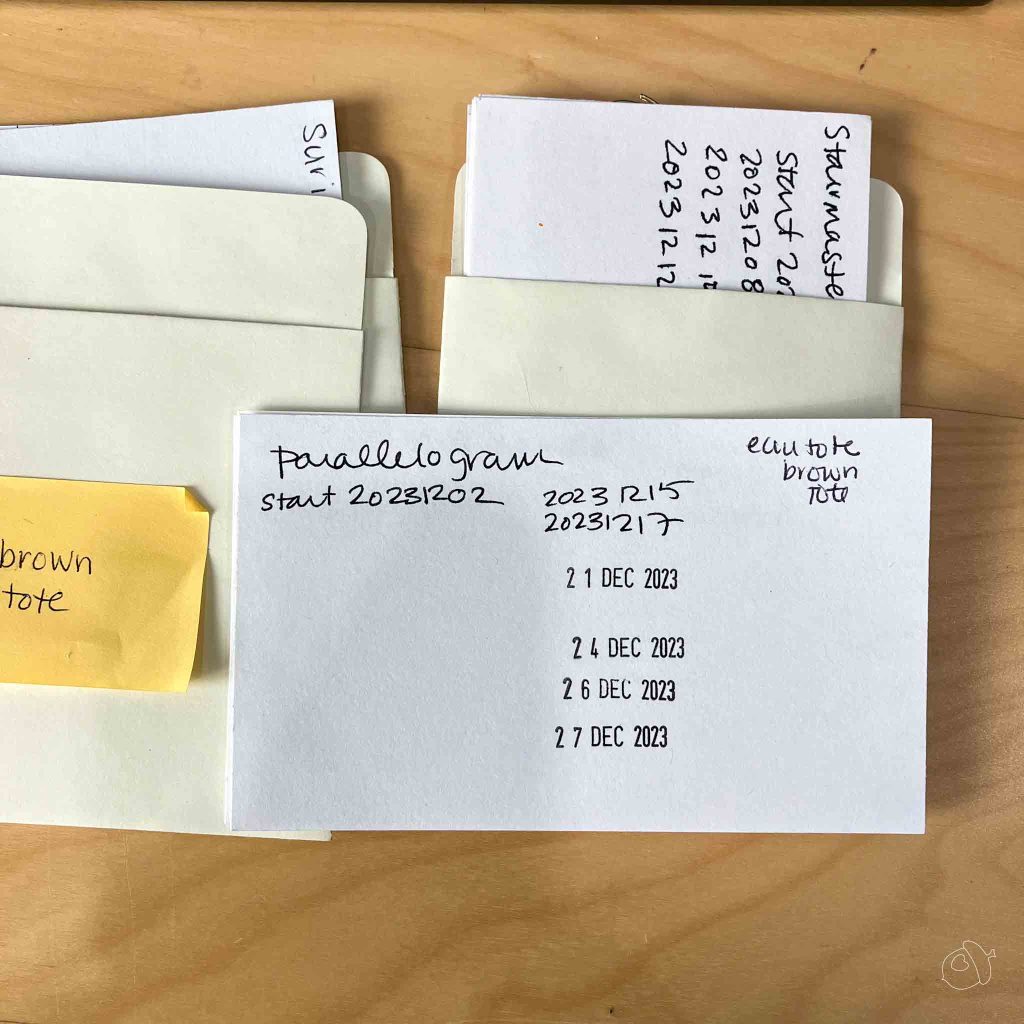 and example of a project notecard. the pattern, start date, and dates it's been worked on some with a stamp, some written are visible.