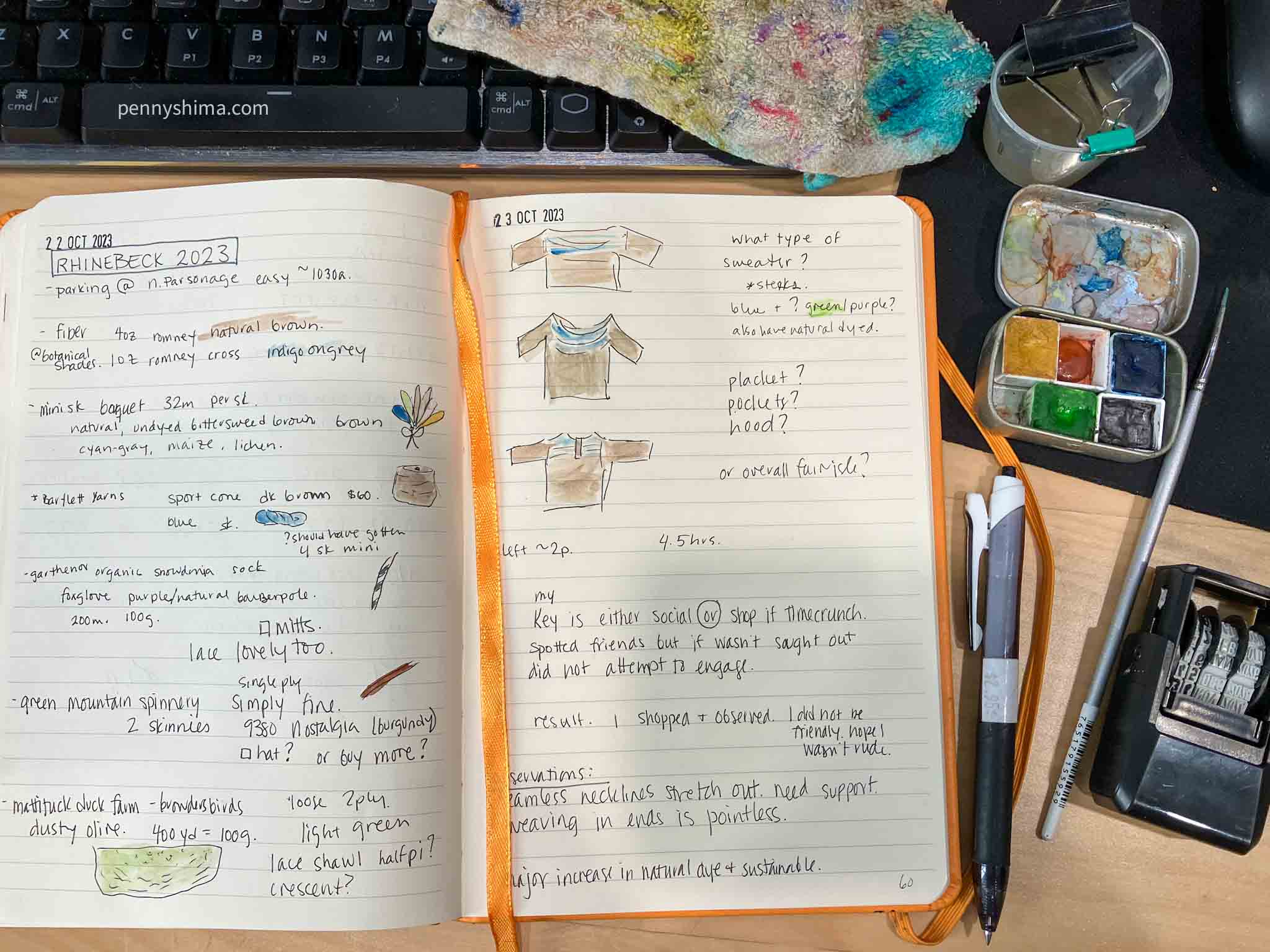 two page spread of an orange lined notebook on a wooden desk with keyboard, mini watercolor set, pen, and date stamp visible.
