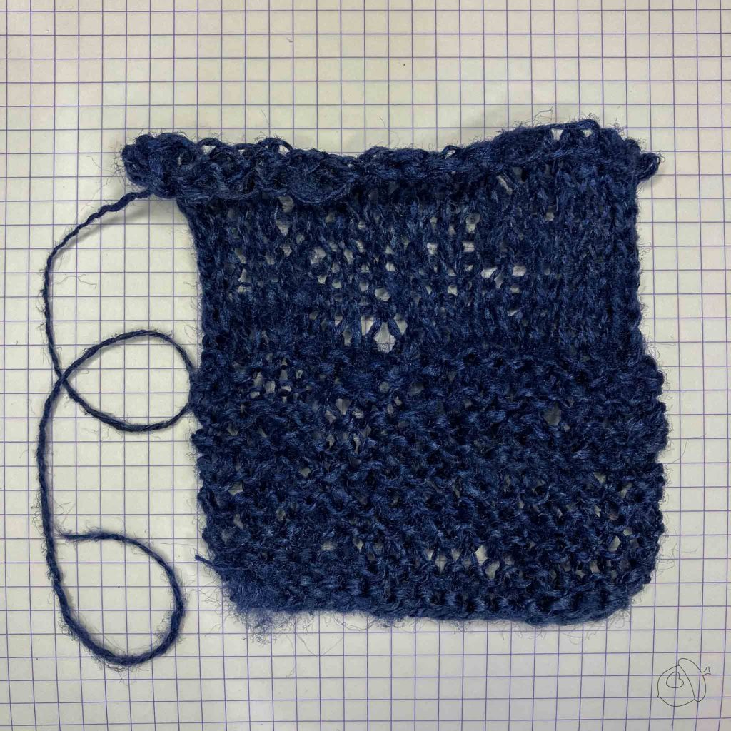 Unblocked dark navy knit swatch of ColourMart fingering weight crepe style silk bakketta