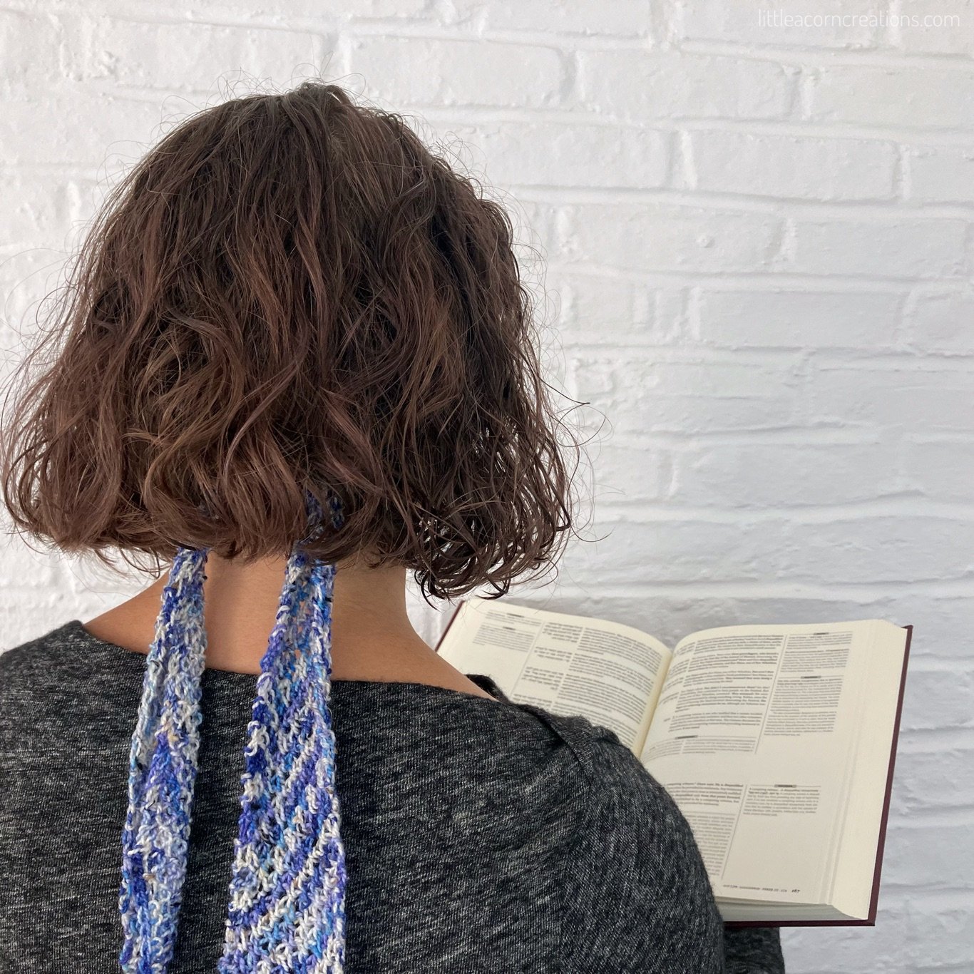 back view of blue "start with chai" knit hair ribbon (modelled)
