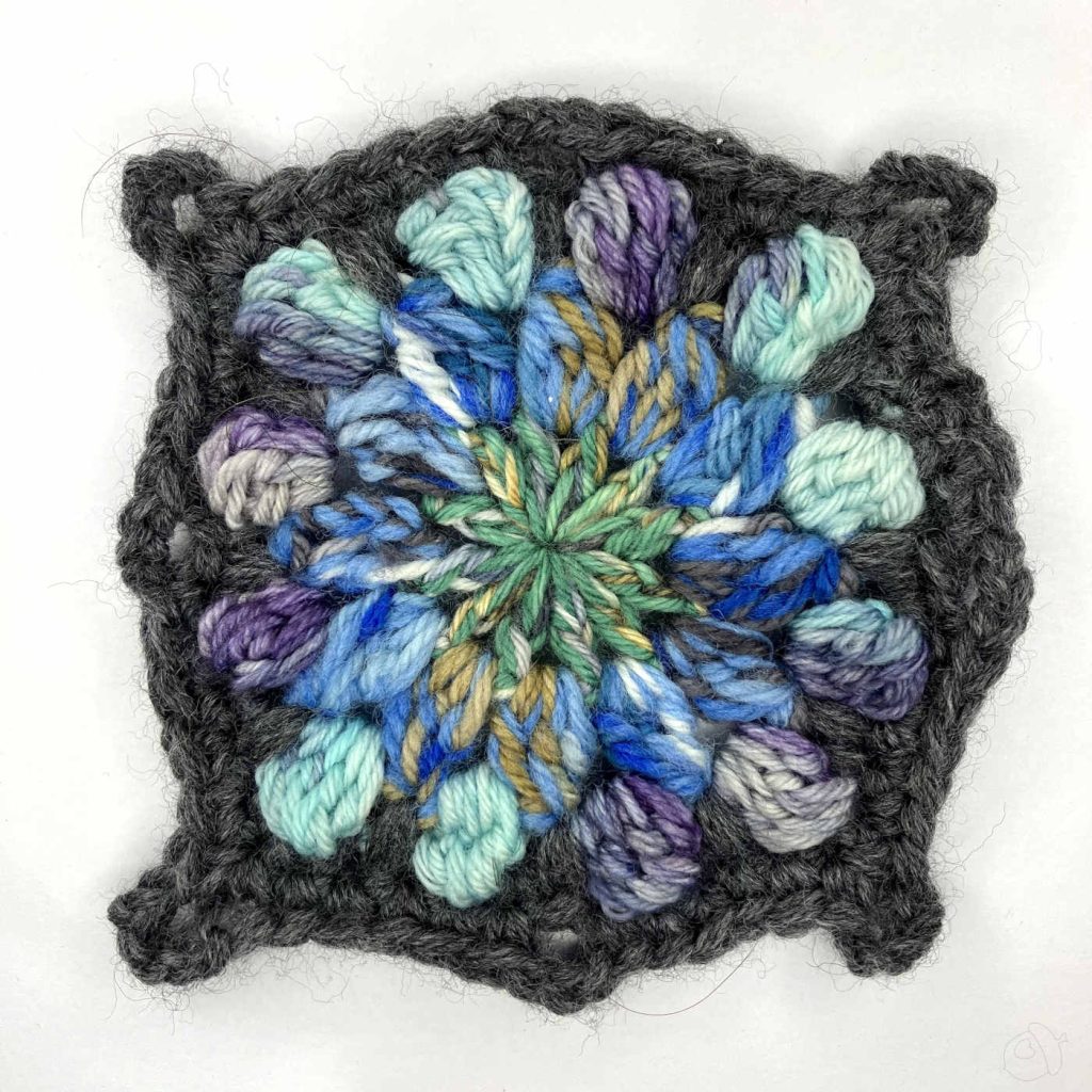 completed crochet motif shown on a white background