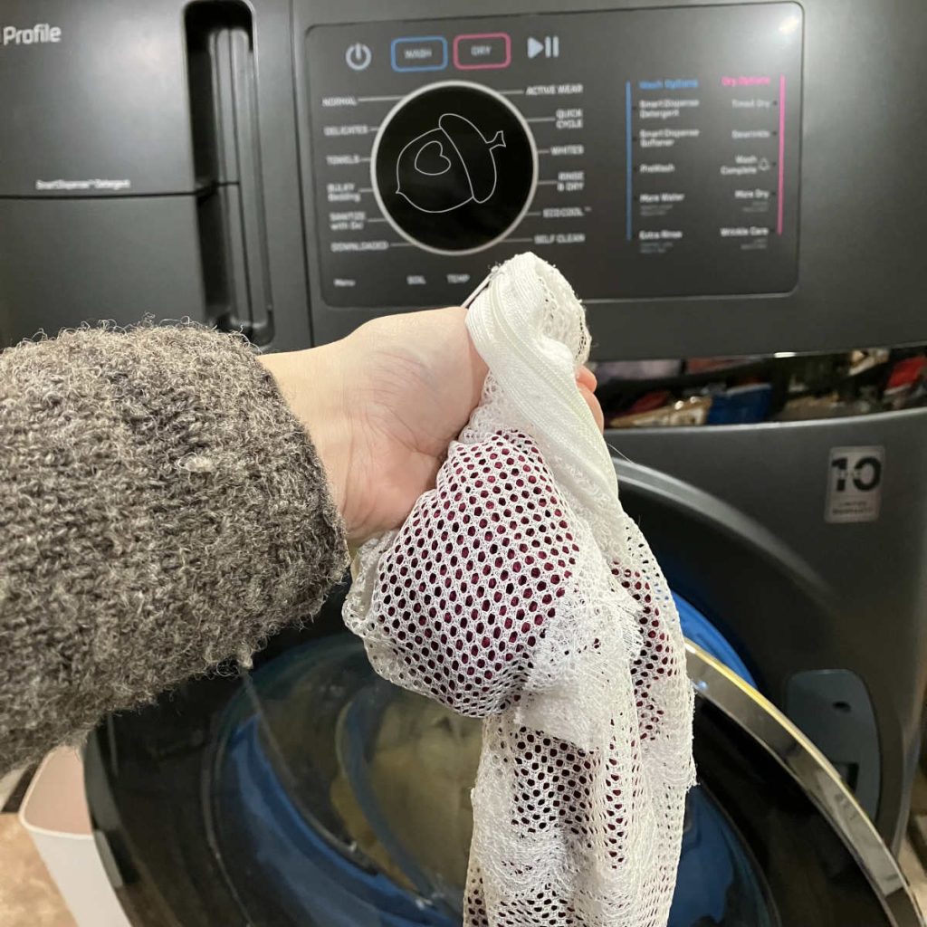 swatches in a delicate care laundry bag held infront of a washing machine