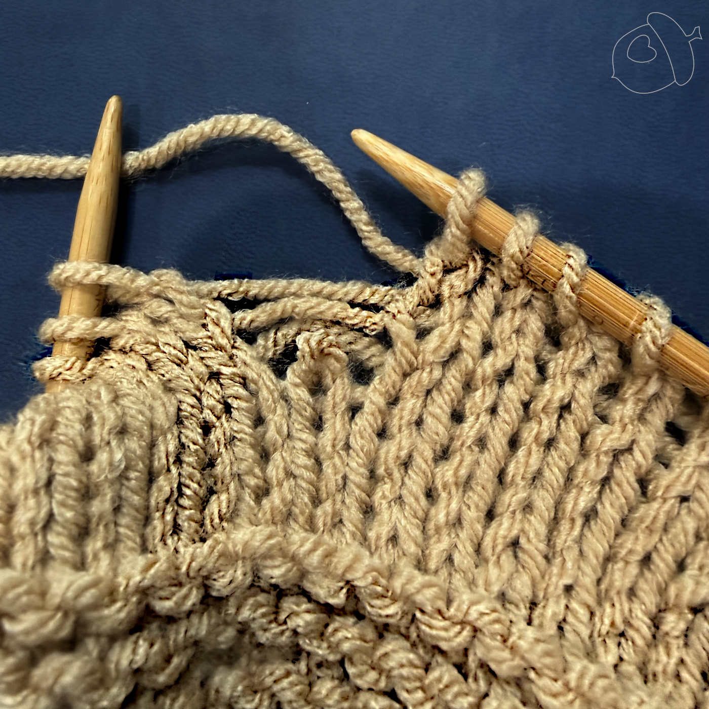 a dropped stitch of light tan knitted fabric on a blue background
